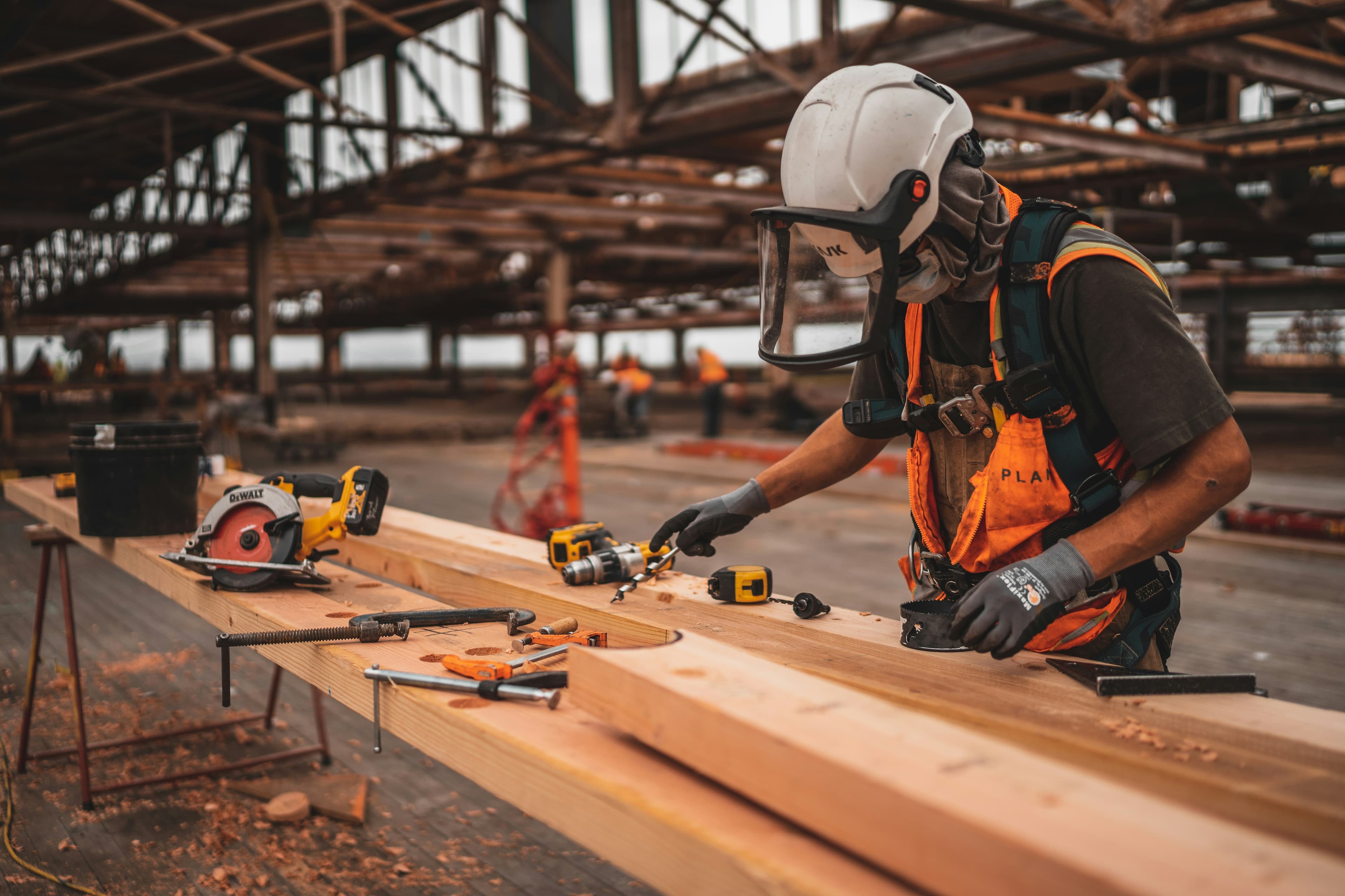Stock reference showing a construction professional working with timber inside a large building under development
