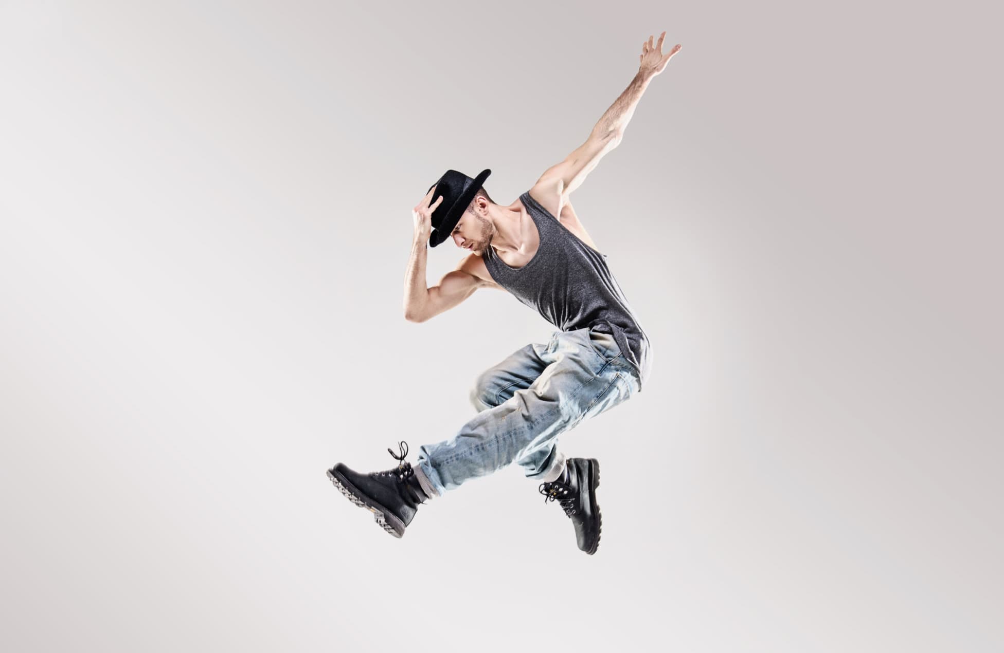An adult hip-hop dancer captured in a dynamic jump