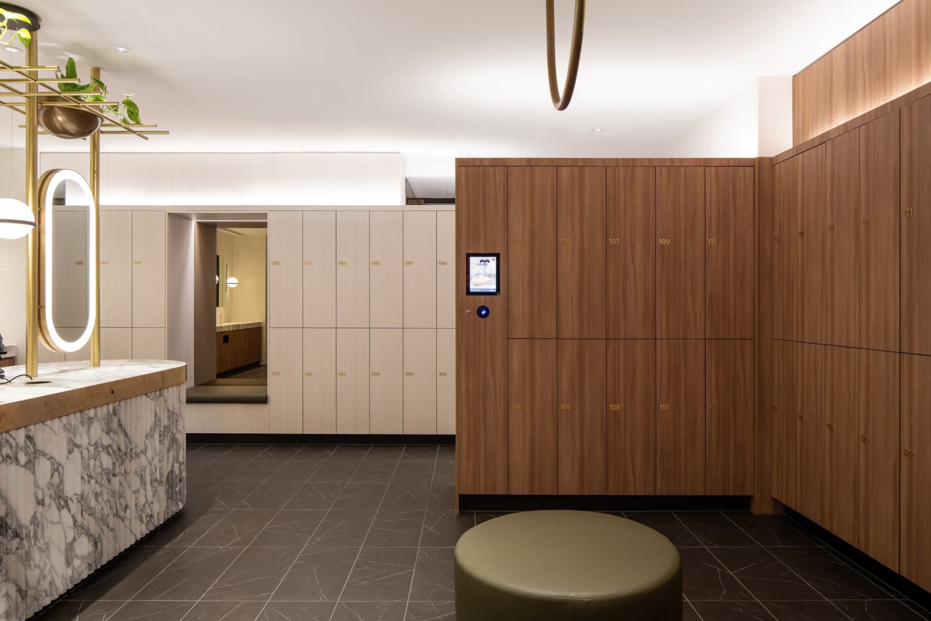 Interior design reference showing warm wood lockers, mirrors and a preparation area